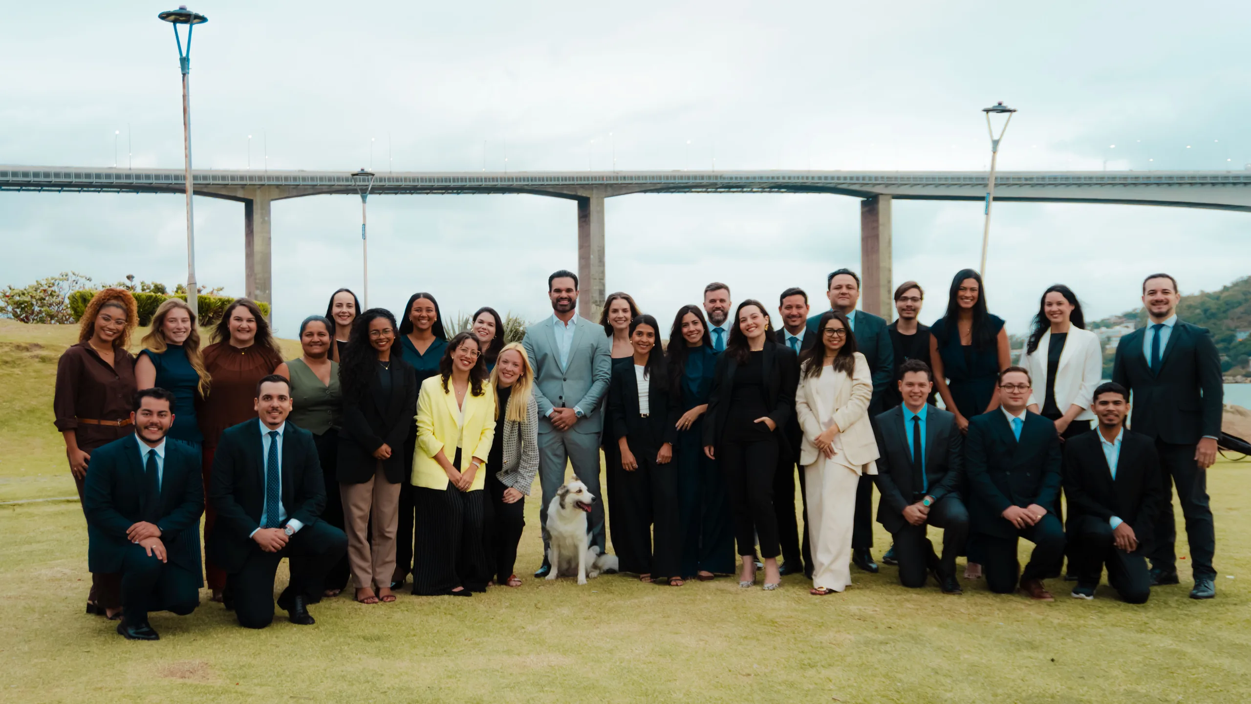 A equipe da FASS reunida ao ar livre, com a Terceira Ponte ao fundo